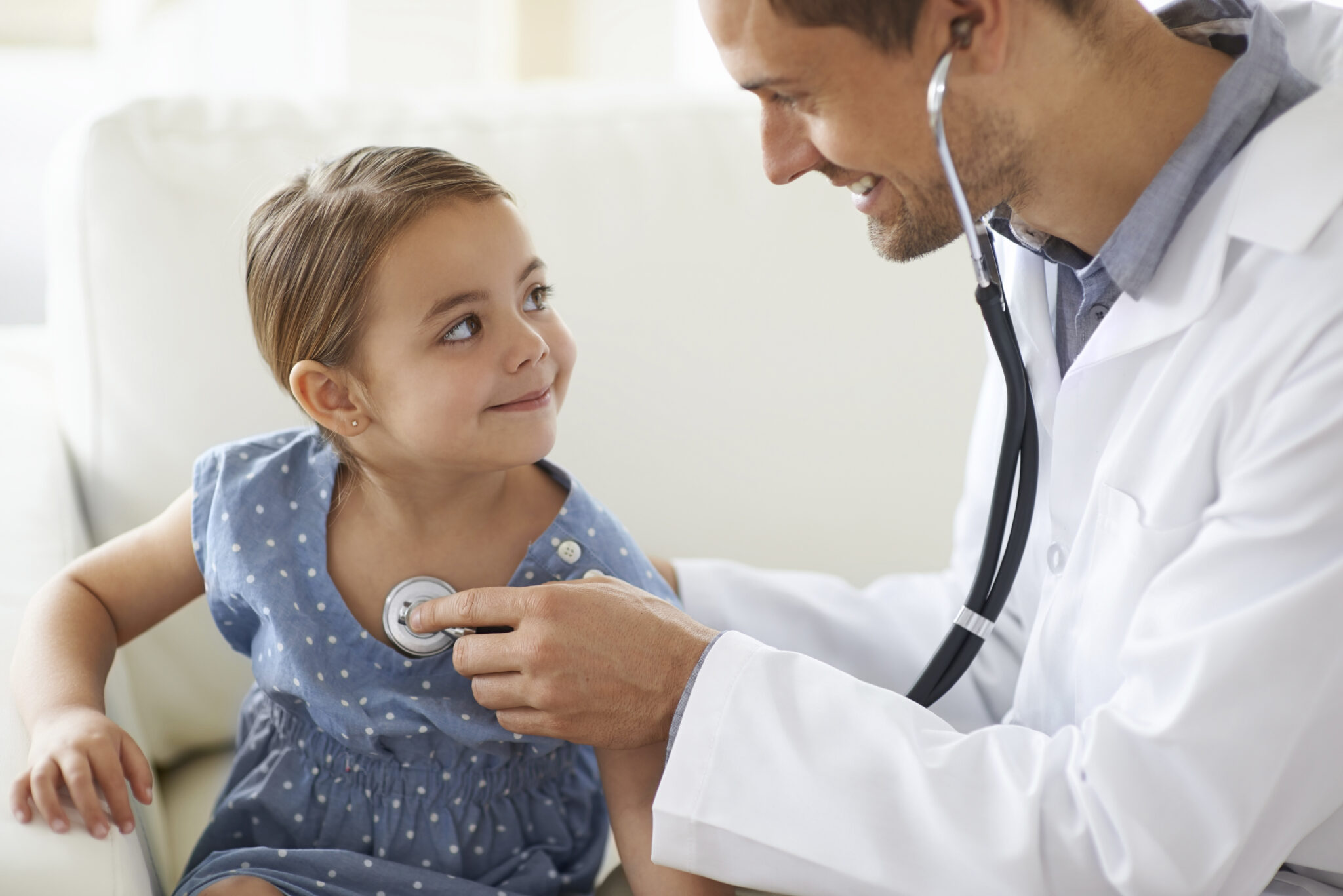 Doctor listens to young patient's heartbeat
